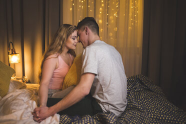 Romantic young couple sitting on bed - AWF00050