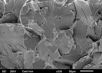 Brüchige Oberfläche aus Gusseisen: Spröde Spaltung mit Flusslinien, aufgenommen im Rasterelektronenmikroskop - CUF28331
