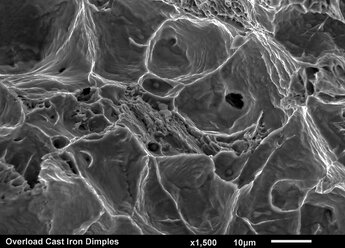 Gebrochene Oberfläche aus Gusseisen: Grübchenüberlastung mit Einschlüssen, aufgenommen im Rasterelektronenmikroskop - CUF28332