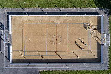 Young man and woman playing basketball, aerial view - STSF01619