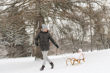 Father pulling little daughter on sledge - DIGF04578