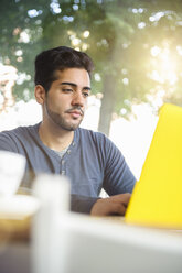 Young man using laptop in cafe - CUF28507