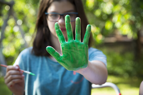 Girl's green painted hand stock photo