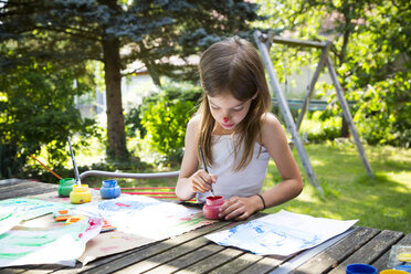Kleines Mädchen malt am Tisch im Garten - LVF07087