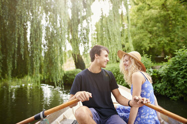 Romantic young couple in rowing boat on rural river - CUF28606