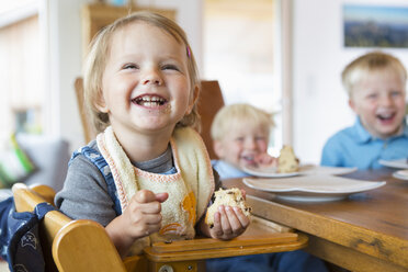 Drei kleine Kinder essen Kuchen am Teetisch - CUF28638
