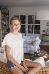 Portrait of pretty teenage girl in living room - CUF28643