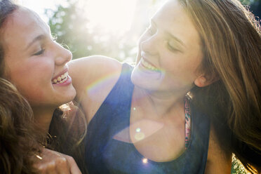 Close up of two teenage girls in sunlit park - CUF28648