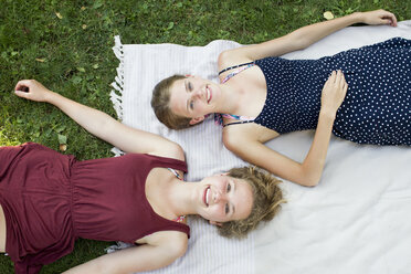 Overhead-Porträt von zwei Teenager-Mädchen liegen auf Picknick-Decke im Park - CUF28649