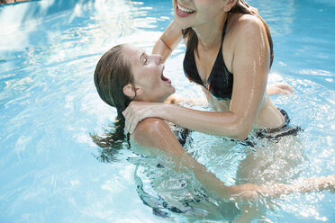 Zwei Mädchen im Teenageralter springen ins Schwimmbad - CUF28657