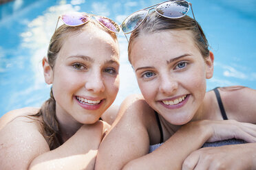 Portrait of two pretty teenage girls at poolside - CUF28659