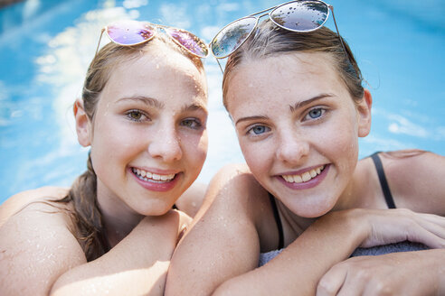 Porträt von zwei hübschen Teenager-Mädchen am Pool - CUF28659