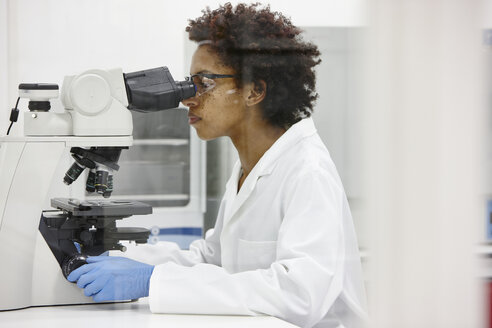 Scientist using microscope in laboratory - CUF28666