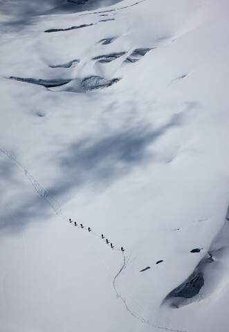 Entfernte Ansicht eines Bergsteigerteams bei der Überquerung eines Gletschers am Mont Blanc, Chamonix, Haute Savoie, Frankreich, lizenzfreies Stockfoto