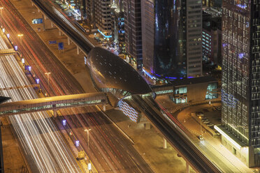 Hoher Blickwinkel auf die Stadtautobahn und die U-Bahn-Station in Dubai bei Nacht, Innenstadt von Dubai, Vereinigte Arabische Emirate - CUF28796