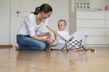 Mother and daughter assembling a chair at home - DIGF04583