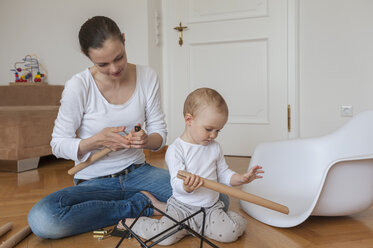 Mother and daughter assembling a chair at home - DIGF04587