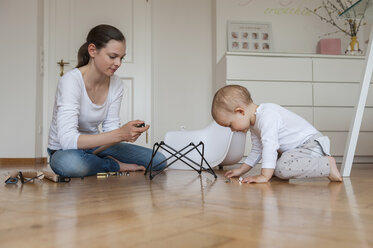 Mother and daughter assembling a chair at home - DIGF04588
