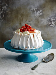 Erdbeerpavlova auf blauem Keramikkuchenständer mit Tortenheber - CUF29066