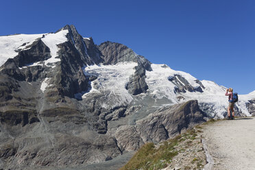 Austria, Carinthia, female hiker with binoculars watching Grossglockner peak, High Tauern National Park - GWF05534