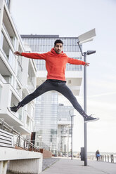 Germany, Cologne, portrait of young man jumping in the air - JATF01047