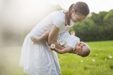 Mutter und Tochter spielen im Sommer auf einer Wiese, lizenzfreies Stockfoto