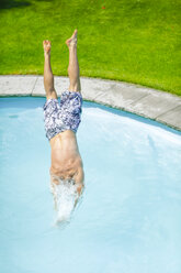 Back view of man jumping into swimming pool - MMAF00393
