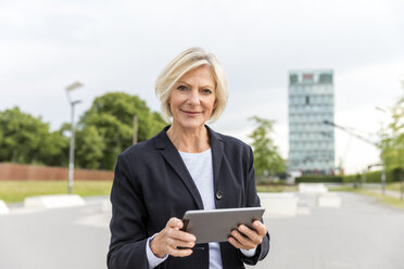 Porträt einer selbstbewussten älteren Geschäftsfrau mit Tablet im Freien - FMKF05136