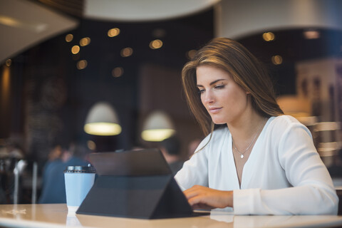 Junge Geschäftsfrau in einem Cafe mit Tablet, lizenzfreies Stockfoto