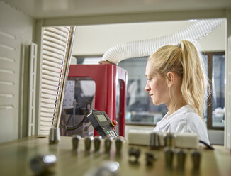 Female technician maintaining CNC machine - CVF00765