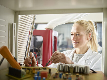 Female technician maintaining CNC machine - CVF00766