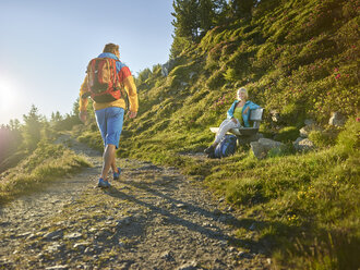 Austria, Tyrol, Couple hiking the Zirbenweg at the Patscherkofel, meeting at a bench - CVF00776