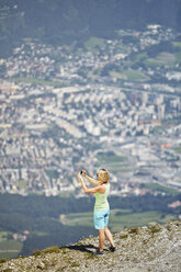 Austria, Tyrol, Woman taking picture of Innsbruck - CVF00785