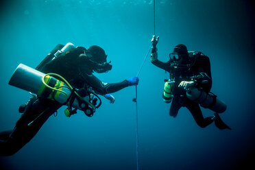 Unterwasseransicht von zwei technischen Tauchern, die ein Kreislaufgerät zur Ortung eines Schiffswracks verwenden, Lombok, Indonesien - CUF29124
