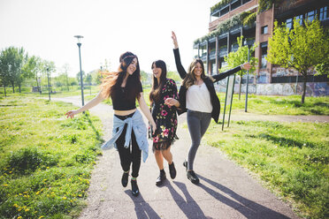 Drei junge Freundinnen tanzen zusammen im Park - CUF29142