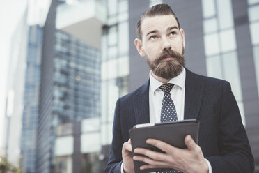 Stylish businessman using digital tablet touchscreen outside office - CUF29174