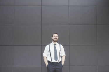 Portrait of stylish businessman with hands in pockets outside office - CUF29176