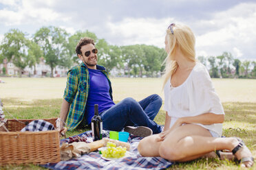 Paar sitzt auf einer Decke und macht ein Picknick - CUF29179
