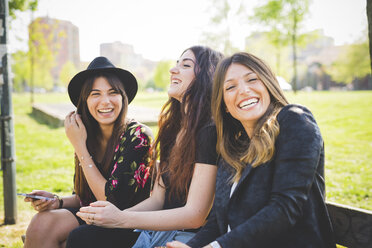 Portrait of three young female friends laughing in park - CUF29191