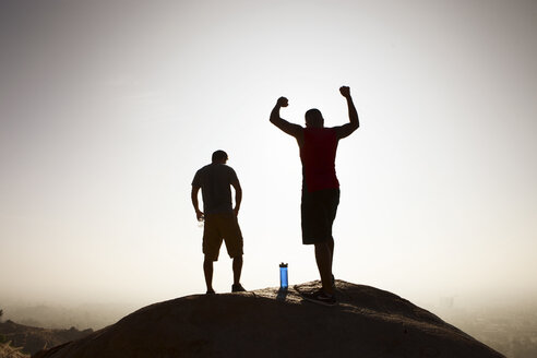 Zwei männliche Freunde, auf dem Gipfel eines Berges, in feierlicher Pose - CUF29250