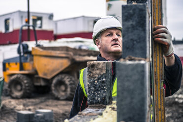 Arbeiter legen Ziegelsteine auf einer Baustelle - CUF29252