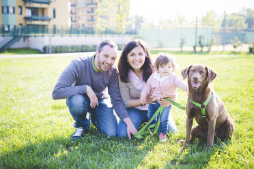 Portrait of mid adult couple with toddler daughter and dog in park - CUF29255