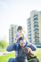 Mid adult man with toddler daughter on shoulders in park - CUF29256