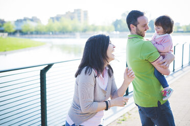 Mid adult couple with toddler daughter at riverside - CUF29258