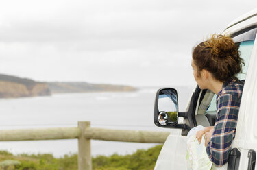 Junge Frau schaut aus dem Fenster eines Wohnmobils, Point Addis, Anglesea, Victoria, Australien - CUF29262