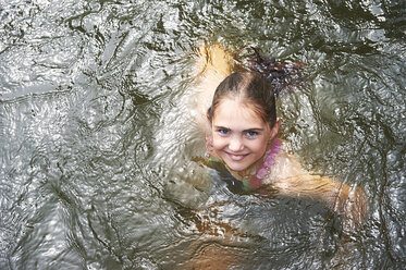 Overhead-Porträt eines Mädchens, das in einem ländlichen See schwimmt - CUF29288