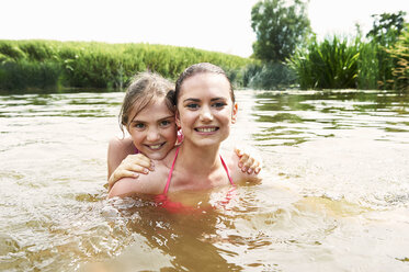 Porträt eines Teenagers und seiner Schwester beim Schwimmen in einem See auf dem Land - CUF29340