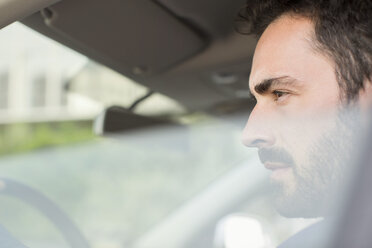 Junger Geschäftsmann schaut aus dem Autofenster - CUF29447