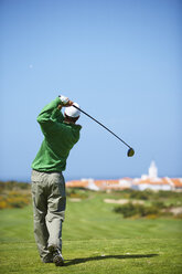 Rückansicht eines Golfspielers, der einen Golfschläger hält und einen Golfschwung macht - CUF29495
