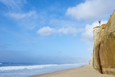 Niedriger Blickwinkel eines Golfspielers auf einer Klippe mit Blick auf den Strand beim Golfschwung - CUF29496